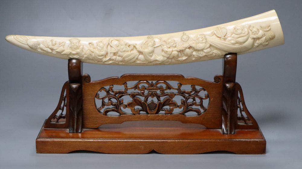 A Japanese ivory Seven immortals tusk carving, early 20th century, wood stand, signed, 44cm excl. stand